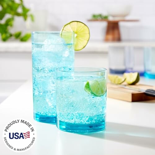 Two glasses of sparkling blue drinks with lime slices.