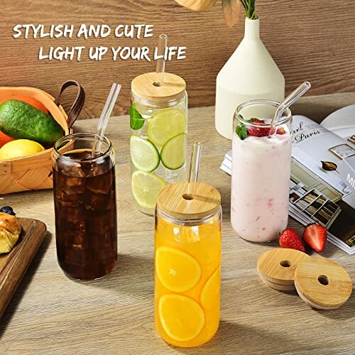 Three glass tumblers with fruit drinks and bamboo lids on a table.